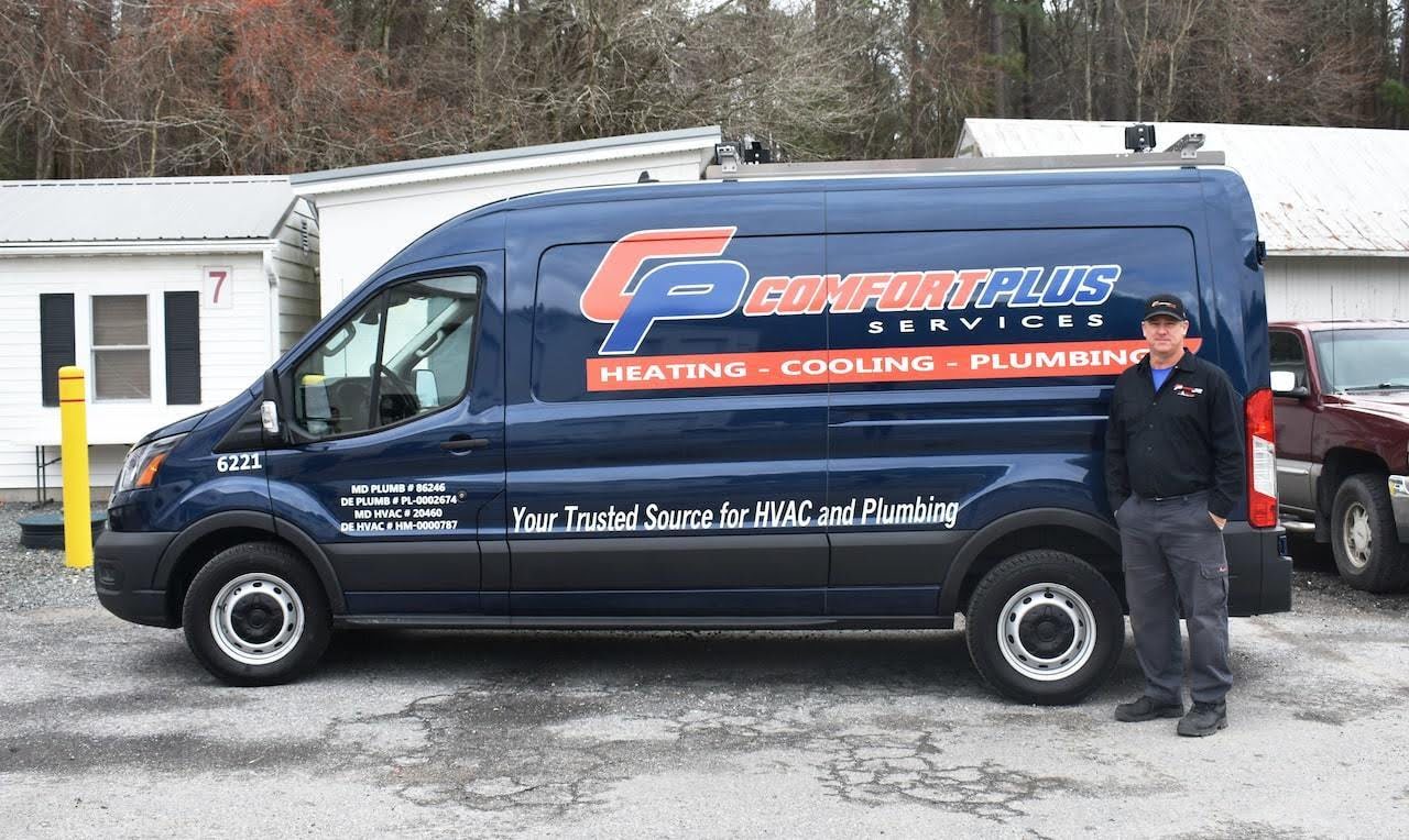 comfort plus van A Comfort Plus Services technician stands beside a company service van used for plumbing, heating, and cooling services with the tagline, "Your trusted source for HVAC and Plumbing."