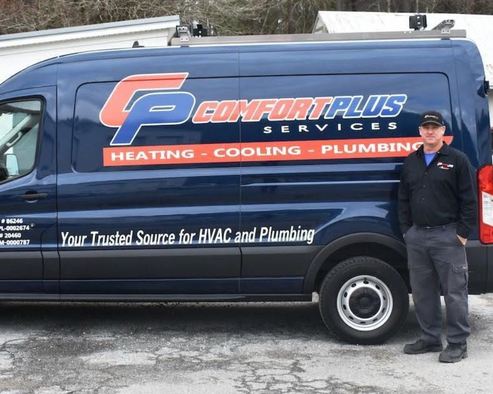 A Comfort Plus Services technician stands beside a CPS service van, used for heating repair, HVAC repair, and plumbing repair and maintenance services.