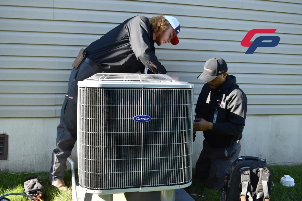 CPS technicians work on an older outdoor HVAC condenser as part of the CPS guaranteed expert HVAC repair service.