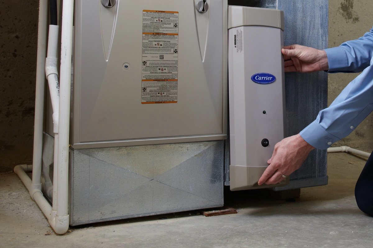 A technician changes a whole-home air purifier filter at a Delmarva residence.