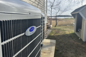 A Carrier Infinity condenser unit sits next to a home with the beach in the background, just 50 yards away.