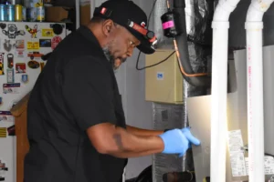 A CPS technician cleans an evaporator coil inside an air handler.