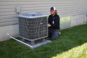 An HVAC technician tests refrigerant levels in a condenser unit that was running, but not cooling the house.