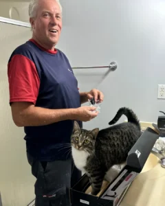 Steve R., Comfort Plus Services Plumber, replaces a bathroom faucet with the help of the homeowner's cat.